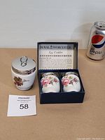 Set of two floral design egg codlers in box, single codler with berry design, soda can for size reference