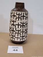 Front view of the Swedish pottery vase showing the detailed geometric pattern and two-tone brown and white glaze.