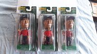 Three Tiger Woods bobbleheads in original packaging, front view showing the packaging design and figure appearance.