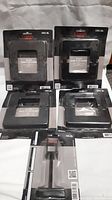 Four black base plate covers and one black stair rail support leg all in original sealed packages