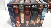 Photo showing seven boxed DVD sets of Buffy the Vampire Slayer, seasons 1 to 7, upright and lined up. Covers feature characters and show branding.