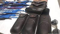 Safety glasses, eyeglass cases lined up showing brand logos like Ray-Ban and Vogue