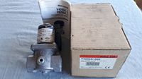 Two Honeywell solenoid gas valves, one in original box, one unpackaged, placed on flat surface for visual inspection.
