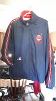 Front view of Cleveland Indians navy blue sports jacket with Chief Wahoo logo and striped sleeves