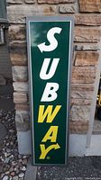 Front view of the large Subway sign showing the 'SUB' in white and 'WAY' in yellow on a green background with a white border.