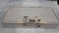 Front view of the sealed white rectangular box labeled Tekmar 152 Two Stage Setpoint Control with handling label and quality assurance.
