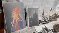 Photo showing all 7 postcards lined up side by side and slightly angled, featuring various historic and scenic subjects including a color illustration and black and white photos.