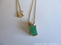 Close-up of emerald-cut green emerald pendant and spring ring clasp