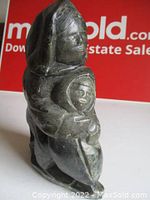 Front angle view of the stone sculpture showing mother holding child.