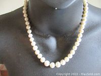 Necklace draped on black bust showing overall appearance and length.