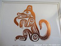Close-up of copper embossed Haida wolf design on white mat