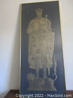 Full frontal view of framed gold rubbing against wall