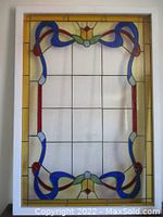 Front view of the entire stained glass panel showing the colorful design and wooden frame.