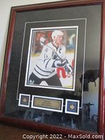 Framed signed photo showing hockey player Mats Sundin in Toronto Maple Leafs uniform with autograph, two pins and NHL logo sticker.