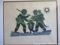 Front view of framed stone cut print depicting Inuit figures ice fishing with a seal and sun symbol, signed and numbered.