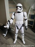 Front view of the large Star Wars Stormtrooper figure holding a blaster standing on floor in a room.