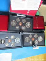 Three open presentation folders displaying Canadian coins in mint uncirculated condition within black foam holders.