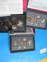 Three sets of Canadian coins each in black leather-like presentation folders with RCM logo showing coin arrangements including large silver double dollar coins with commemorative designs.