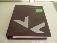 Front view of the dark maroon Unity brand Canada stamp album with silver logo and label.