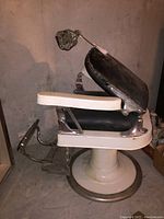 Side view of chair showing pedestal base, armrests and backrest.