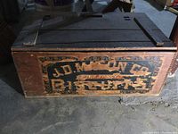 Front view showing wooden crate with branded and worn paint reading 'J.D. Mason Co. Fine Fancy Biscuits'.