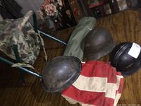 All items on table: three helmets, stool, chair bag, flag