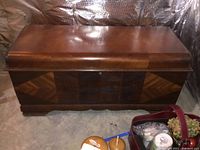 Front and top view of Lane cedar chest showing wood veneer and geometric patterns with scratches and peeling veneer visible on top and sides.