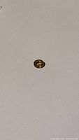 Natural yellow sapphire gemstone laid on white background showing oval cut and bright golden hue.