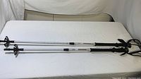 Pair of Komperdell trekking poles laid out with visible markings and grip handles