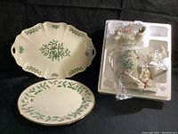 View of two serving platters and the Holiday Santa Teapot in packaging wrapped in plastic