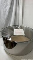 Large 32 QT Princess House tamalera pot with glass lid and attached handle, pictured against a white cloth background.