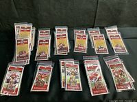 Overview of all 11 pins arranged on black surface in original packaging, showing team and player imagery.