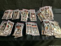 Photo of all 9 San Francisco Giants commemorative pins laid in groups on black fabric, each in its own clear plastic sleeve with printed cardboard backing.