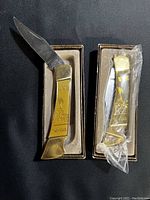Two WWII commemorative pocket knives in original boxes, one open and one still wrapped in plastic