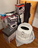 Overview showing boxed Salton Hot Spot Set, Maxim Hot Mug Set, Black and Decker Dust Buster in box, and the Rival deep fryer on the floor.