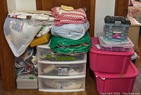 Full view of all storage containers and fabric items stacked near a wooden door