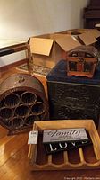 Wide view showing the round rattan wine rack, small wooden chest with upholstered top, wooden rack with family sign, and two smaller signs on top