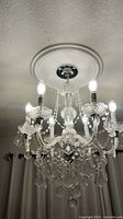 Overhead view of six-arm chandelier suspended from decorative ceiling medallion