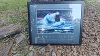 Framed picture showing lighthouse in stormy sea and part of the motivational text below image.