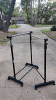 Clothes rack set up outside on driveway, view showing frame and hanging bars.