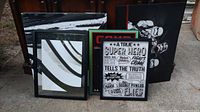 Photo of 5 framed wall art pieces: two large abstract paintings, 'GAME' print, superhero text print, smaller abstract print
