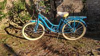 Full side view of vintage blue Schwinn bicycle with white tires and rear cargo rack.