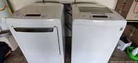 Front view of both white LG top-load washer and dryer side by side