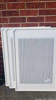 Three white IKEA picture frames stacked, showcasing clean edges and size.