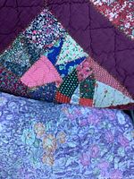 Patchwork quilt featuring various floral and geometric patterns and multicolored fabrics