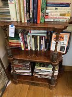 Full view of three-tier wooden shelf showing turned supports, carved details and overall condition