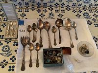 Overview of two boxed enamelled utensils, serving fork, spoons, jewelry box with rings, hair comb, small glass dish with earrings