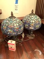 Two matching lamps with cords and a small box of bulbs for scale