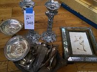 overview of lot showing sterling platter, compotes, pitchers, utensils on pewter tray, pewter candlesticks, framed portrait