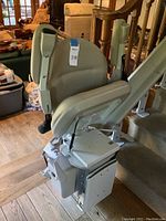 Stair lift seat and carriage assembly on track at bottom of stairs